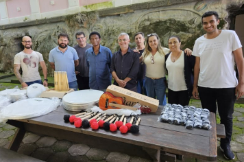 Entrega de um instrumento musical e equipamentos de percussão